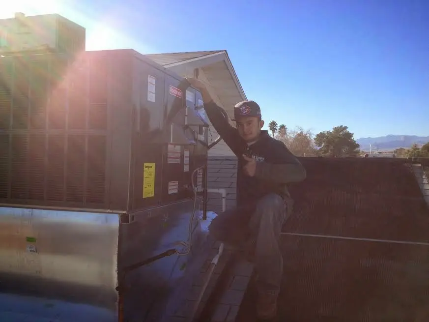 HVAC technician performing Air Duct Repair on a rooftop unit in East Hartford